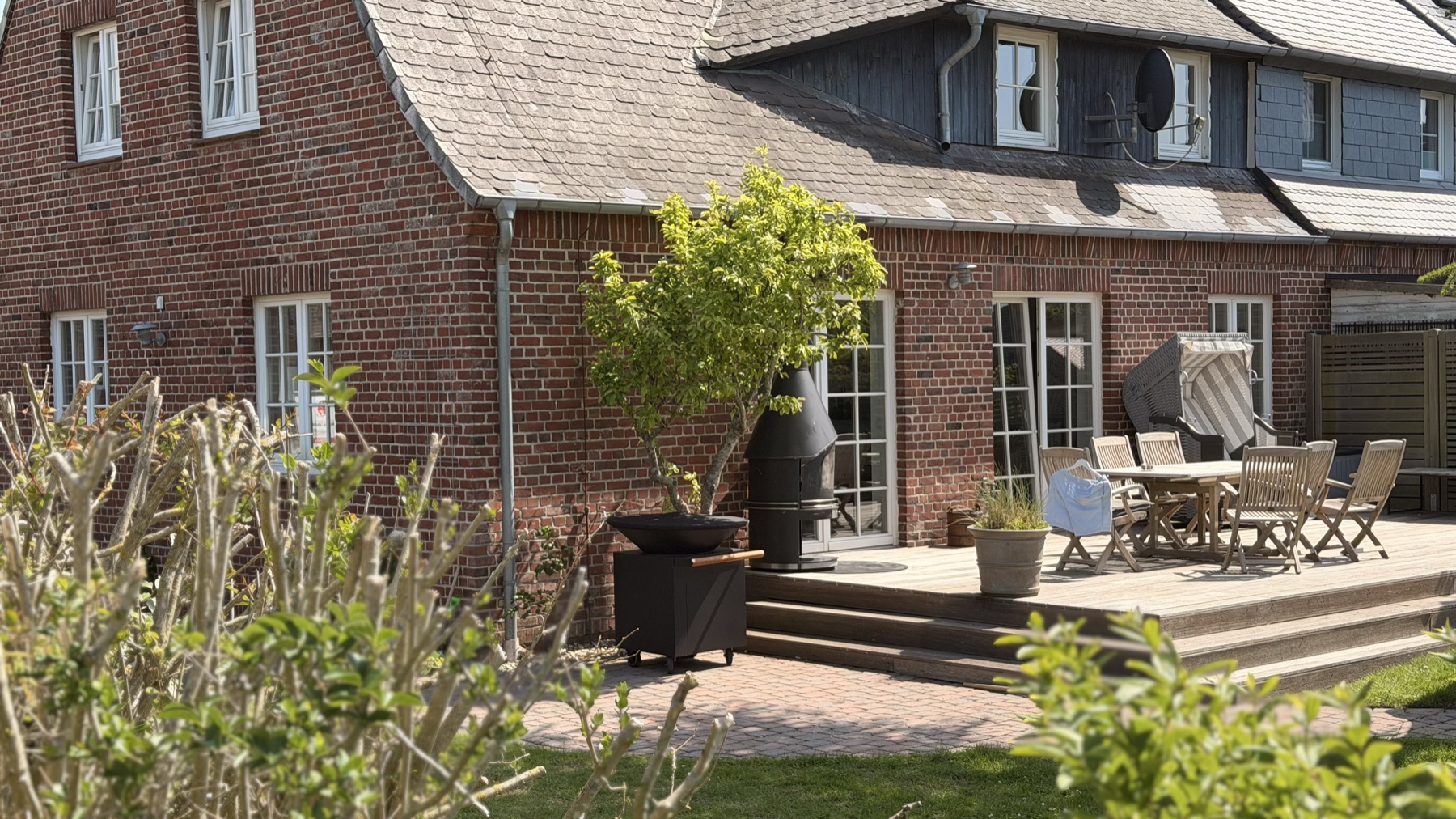 Blick über den eingezäunten Garten auf das Ferienhaus Lüttje Butt