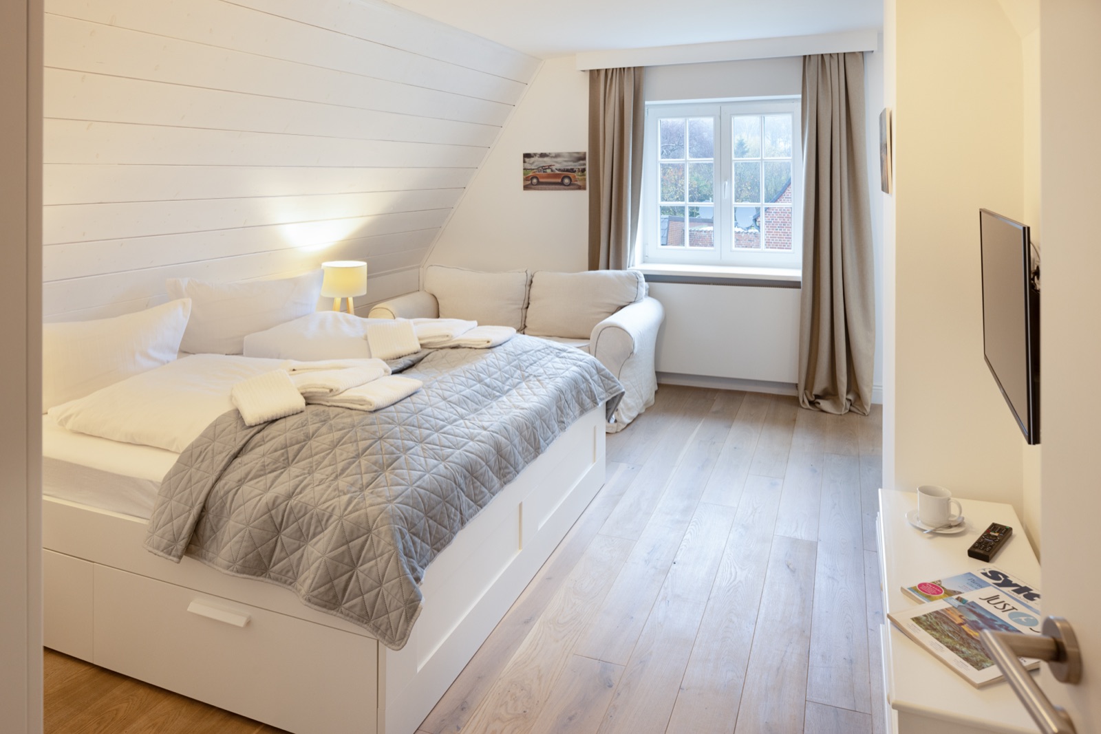 Helles Schlafzimmer mit Doppelbett unter der Dachschräge